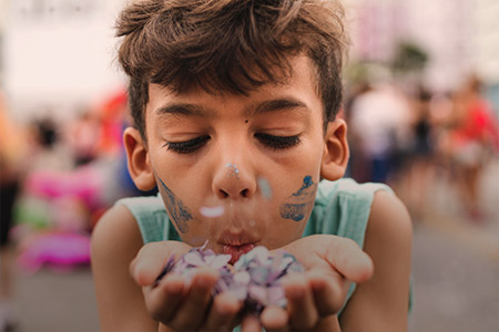 Foto de uma criança pintada assoprando